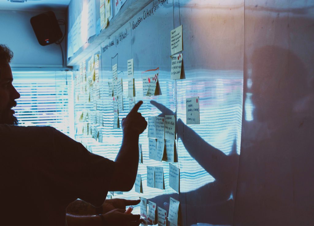 Team arbeitet mit Sticky Notes an einer Bürowand